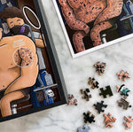 Caja del Puzzle de tatuajes junto a piezas sueltas armadas, diseño de Ingesman