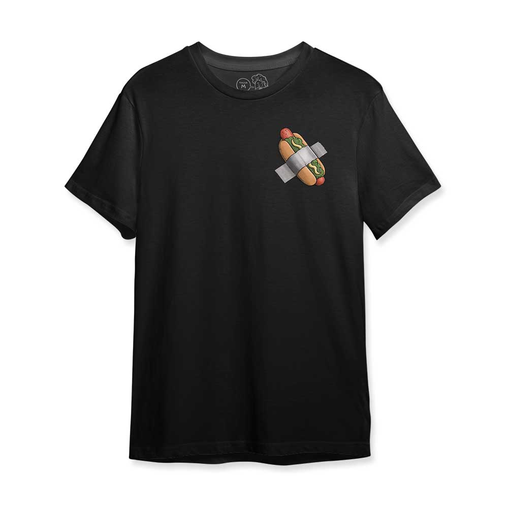 Vista frontal de la polera negra Comedian, estampado pequeño de un hot dog pegado con cinta