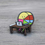 Pin Diseñador Gráfico Ingesman sobre mesa de madera