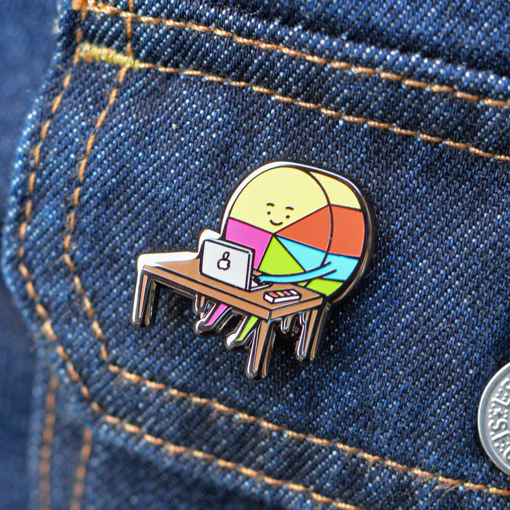 Pin Ingesman con diseño de diseñador gráfico usado como accesorio en chaqueta de jeans